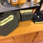 Mostly green but a couple greys. Womans small, med and large in Grey. Fair warning - these are sized small, more like a Junior size but they were labeled as "Ladies". All the greens are mens small thru -xl. $35 including shipping. (The blacks are sold) shirts